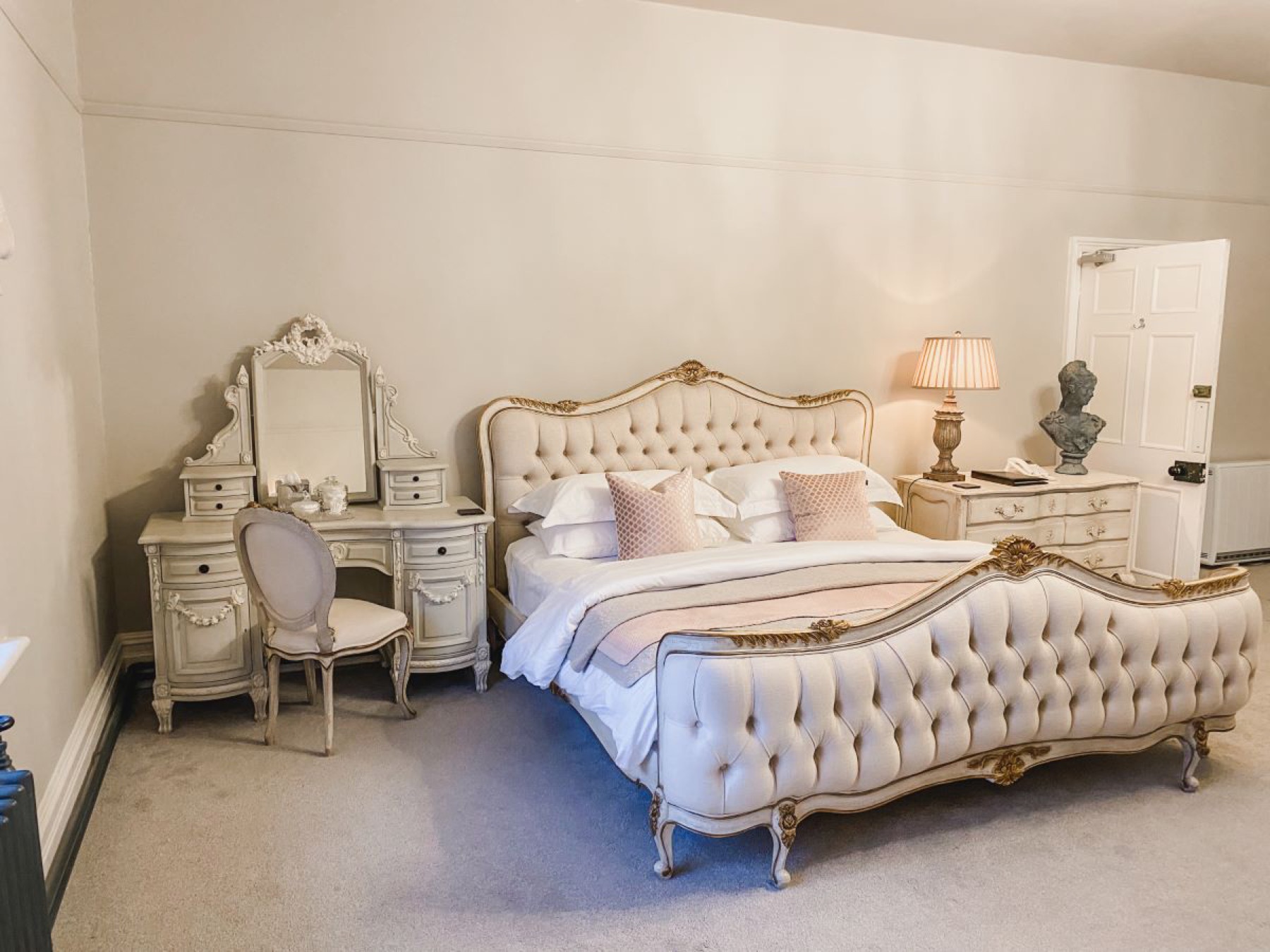 The Gainsborough bedroom at Glewstone Court — an ornate French-style bed, dressing table and chest of drawers